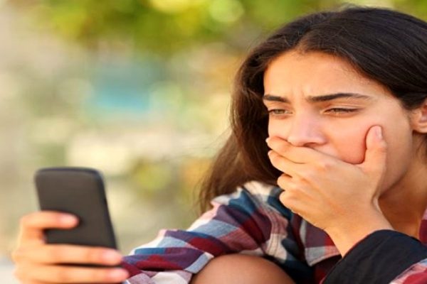 worried woman looking into phone
