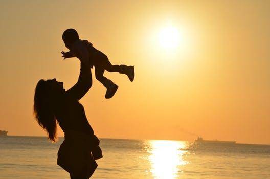 mother and child at beach in sunset