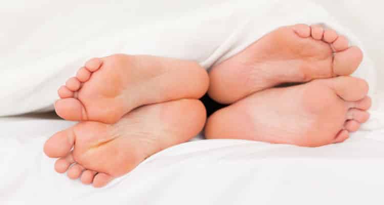Couple's feet on bed