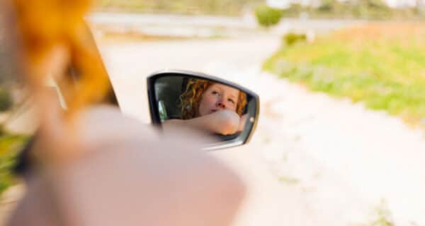 Mirror image of female riding in car