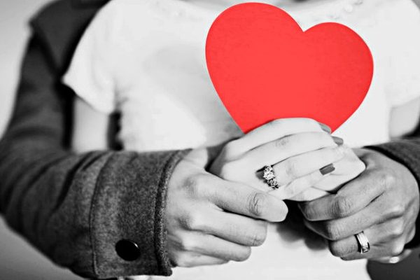 a couple holding a red heart