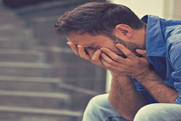 a man weeping in to his hand