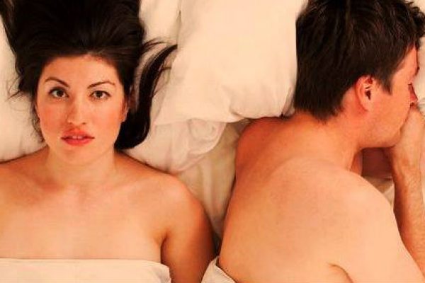 man and sad woman in bed