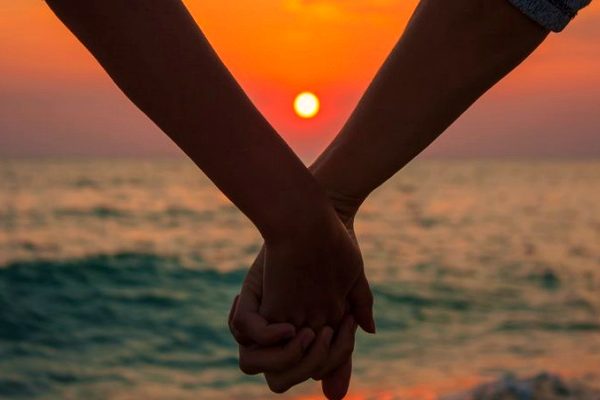 silhouette of couple holding hands