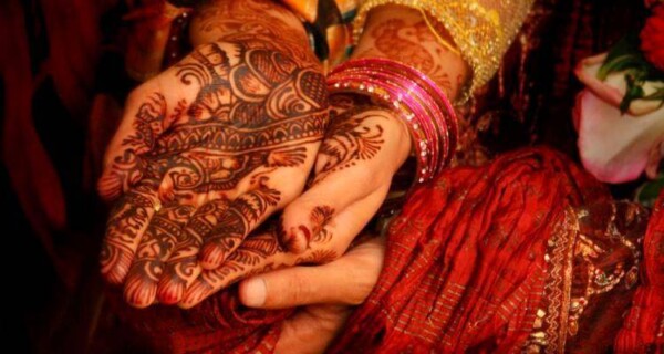 Indian groom holding hands of his bride. Even for a second marriage men tend to be in a better bargaining position