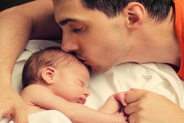 Loving father kissing baby