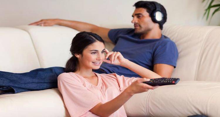 Wife watching tv as husband listens to music