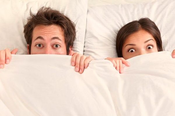 funny wide eyed couple in bed