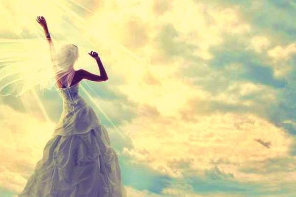 girl in wedding gown looking up at sky