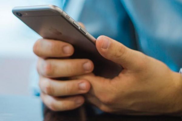 Pair of male hands holding mobile phone