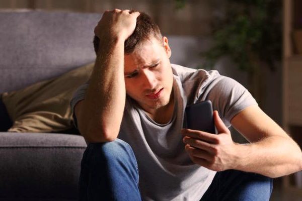 sad man looking at phone