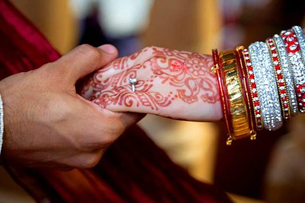 close up of Indian bride and groom hands