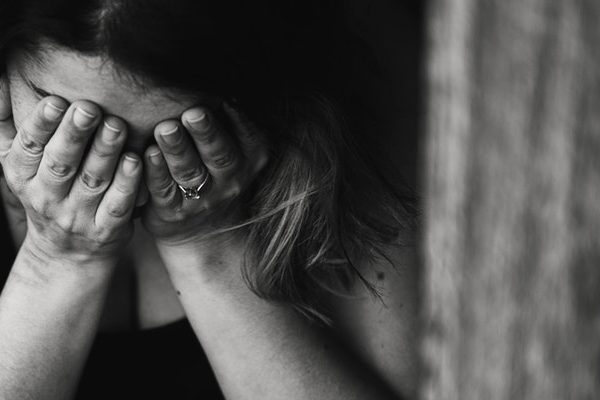 a woman weeping into her hands