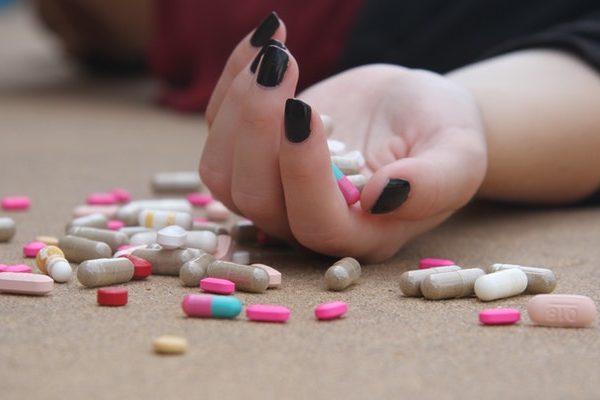 pills on a female hand lying on the floor