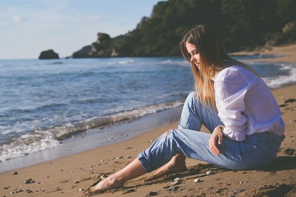 Girl sitting by the beach