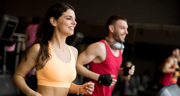 young-couple-running-treadmills-modern-gym