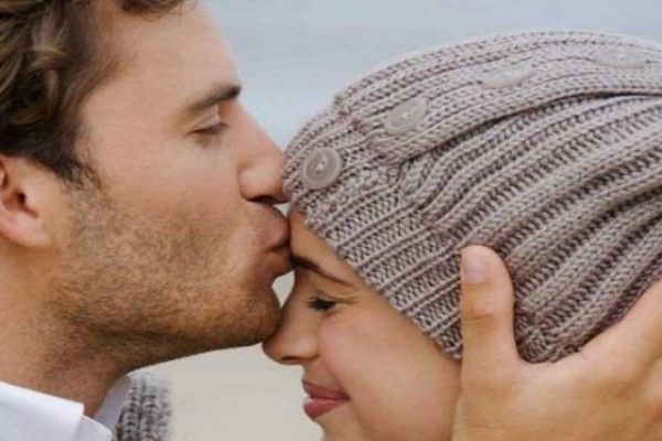 Man kiss on forehead of her woman