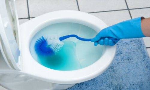 man cleaning toilet seat