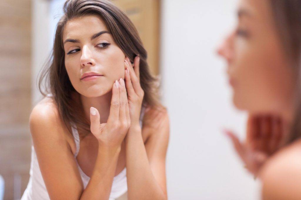 woman checking acne-PMS symptoms
