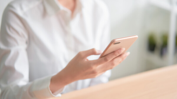 close-up-hands-using-smartphone-wooden-table-typing-message-his-friends