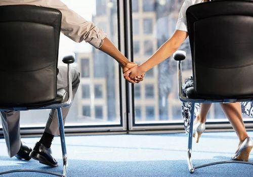 man and woman holding hands in office
