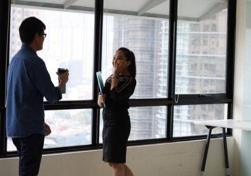 man and woman talking in the office