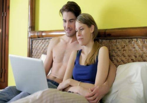 man and woman watching on laptop