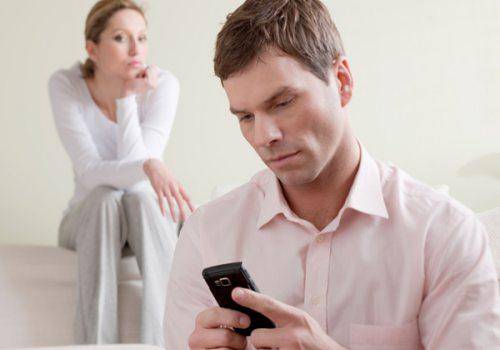 man checking phone and woman seeing