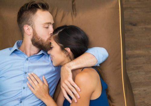 man kissing woman on forehead