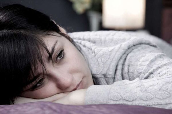 sad lady lying on bed