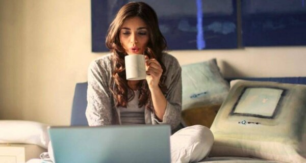 Woman on bed working on laptop