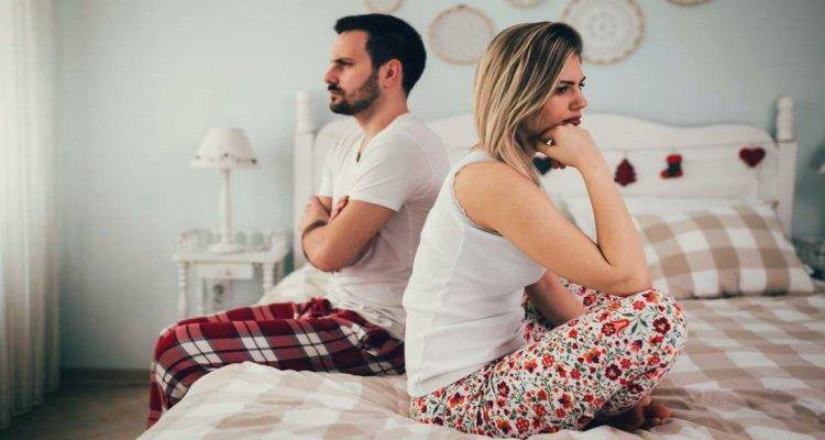 couple sitting on bed and not talking