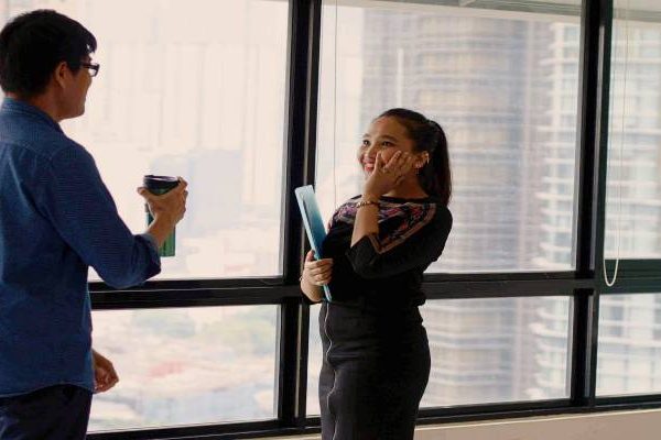 man and woman in office corridor