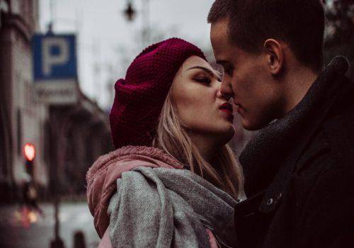 man and woman kissing on the road