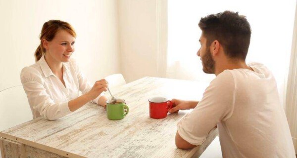 man and woman talking while having coffee