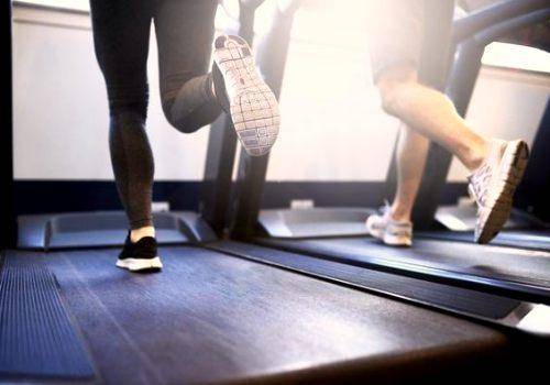 man and woman's foots on a treadmill