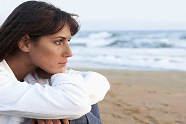 sad lady sitting on the beach