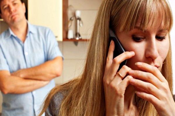 woman on phone hiding from man