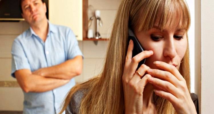 woman on phone hiding from man