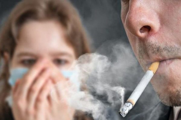 husband smoking in front of wife