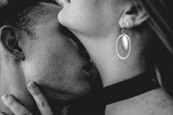 man kissing on neck