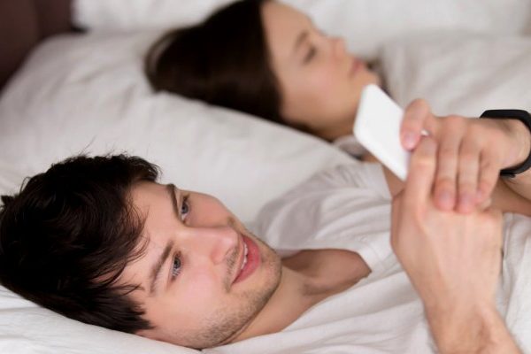man typing message on phone