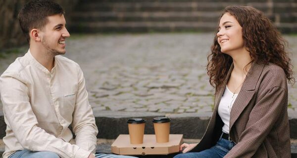 smiling-love-couple-sitting-stairs-outdoors-hold-cups-coffee