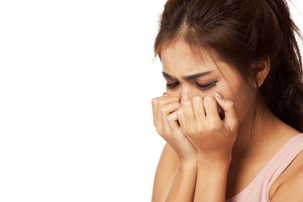 young girl crying into her hands
