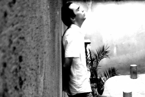 Man standing with back to wall
