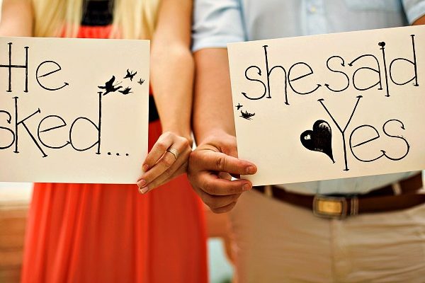 man and woman holding a sign of yes