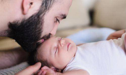 man kissing baby