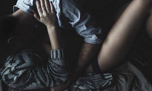 sexy man and woman in bed in dark background