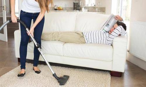 woman cleaning and man resting