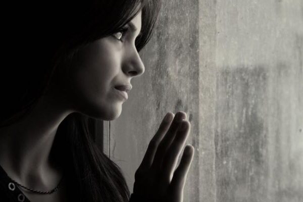close up of sad woman looking out the window